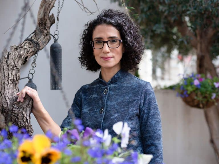 סופרת עומדת ליד עץ